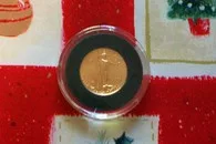 A 1999 gold eagle coin against Christmas wrapping paper. 