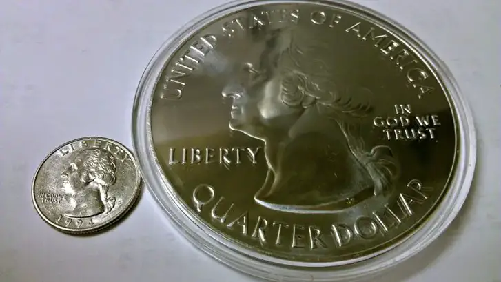 You can see just how large the 5 oz America the Beautiful silver bullion coin is, compared to a standard U.S. quarter.