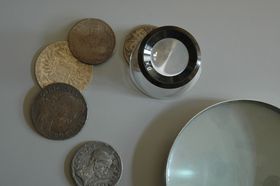 using a coin loupe to look at coins close up