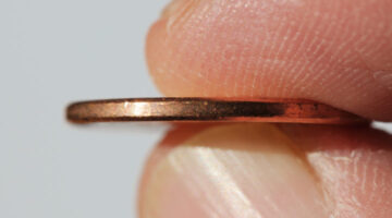 A closeup of the smooth edge of a penny.