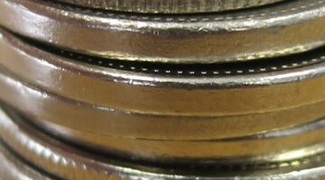 The edge of a coin close up - The reeded edges and plain edges, seen here, are two of the most commonly encountered types of edges seen on modern United States coins. 