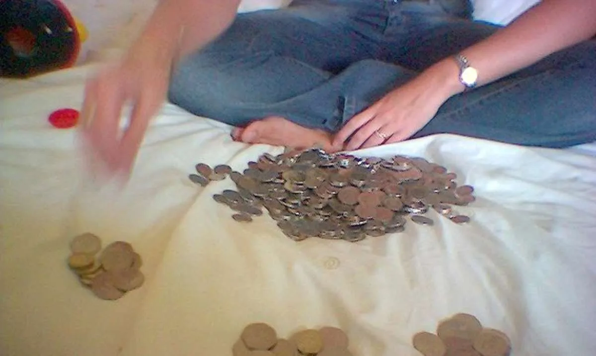 Sorting the coins from my spare change jar on the bed.