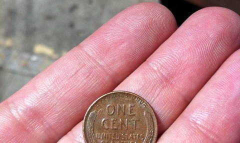 Holding a wheat penny. 